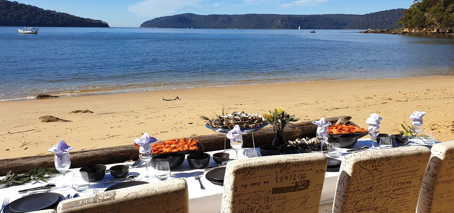 Table set up on secluded beach with oysters and prawns